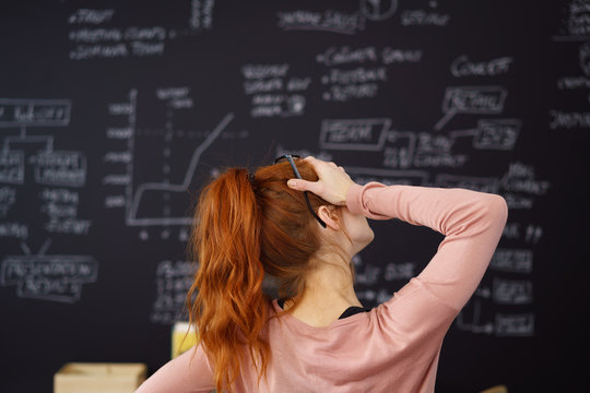 verzweifelte studentin steht vor einer wand mit formeln