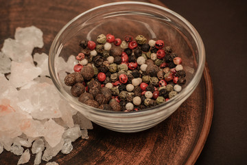 Set of whole peppercorns and rose salt. Handful of red, black, white peppercorns and salt on a argil plate. Herbs and spices concept