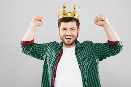 Cheerful young man in green checked shirt and crown