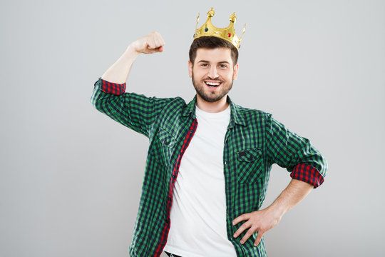 Young man in crown showing strength
