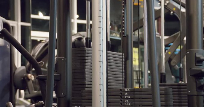 The weight stack from a cable exercise machine 4k close-up video. Gym and workout equipment for training. Working mechanism of rack machine: plates weighs twenty kg moves, lifts, rises and pulls up