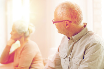 senior couple sitting on sofa at home