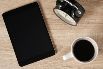 Blak teblet screen and coffee from top view