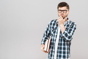 Thoughtful man holding colorful books