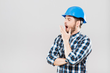 Man in blue building helmet yawning