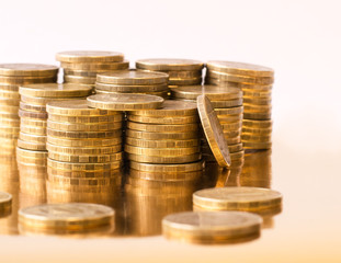 Metal coins are stacked on the golden table.