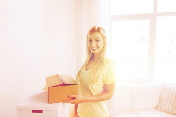 smiling young woman with cardboard box at home