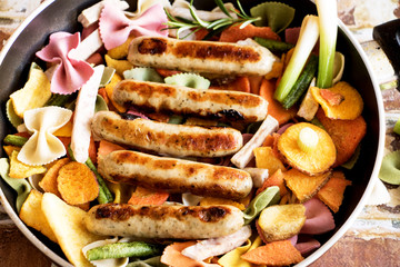 Bratpfanne mit Würstchen, Gemüse und Nudeln