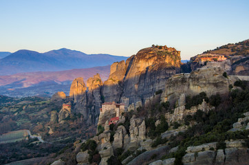 Fototapeta na wymiar Breathtaking panoramic view of Meteora at sunset, Greece. Geological formations of big rocks with Monasteries on top of them.