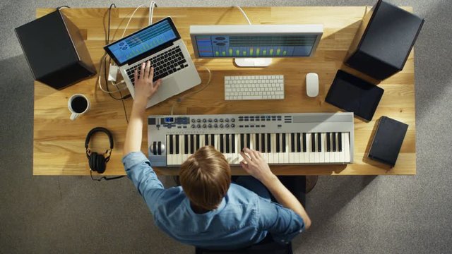 Top View of a Musician Creating Music at His Studio, Playing on a Musical Keyboard. He Dances While Creating Music. His Studio is Sunny and Pleasant Looking.  Shot on RED Cinema Camera in 4K (UHD).