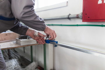 Factory for aluminum and PVC windows and doors production. Manual worker assembling PVC doors and windows. 