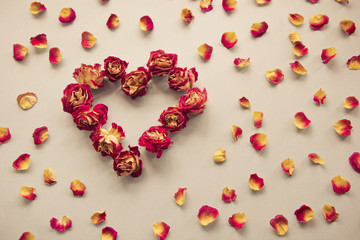 Valentine's card. Heart symbol made of dried roses on a vintage background. Top view, flat lay. Concept, postcard with place for your text. Vintage filter.