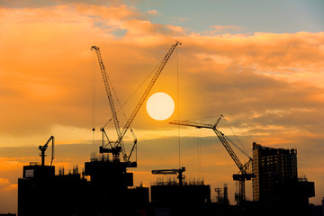 Obraz premium Construction site silhouette on tower building rooftop twilight