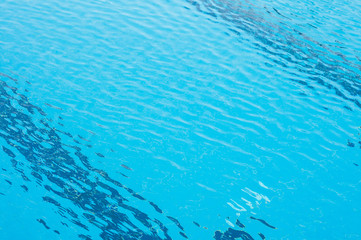 Fototapeta na wymiar Blue ripped water in swimming pool. Pool water background. Swimming pool with stair in hotel. Summer photo concept.