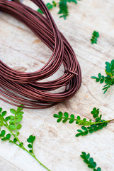 Garden wire on rough wooden background.