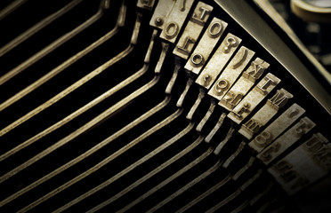 Macro view of type characters of an antique typewriter. Hard focus on the center of the image and soft focus at the edges 