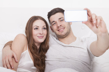 mann und frau machen selfie im bett