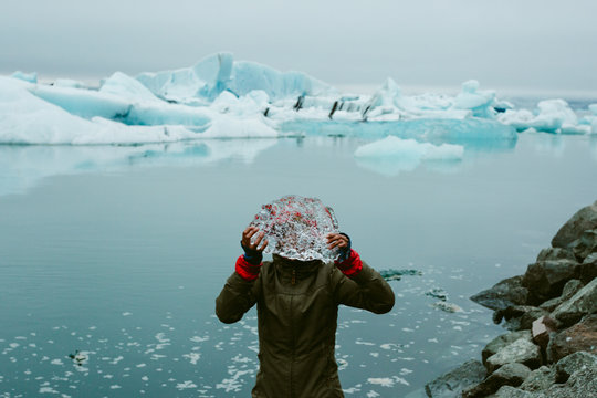 Woman looking through ice by sea