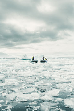 Boats and crew on icy sea 