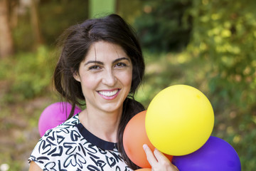 Young pretty woman holding colored balloons