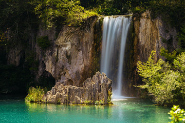 Fototapeta na wymiar Waterfall and a lake with a stone in the Plitvice Lakes National Park.