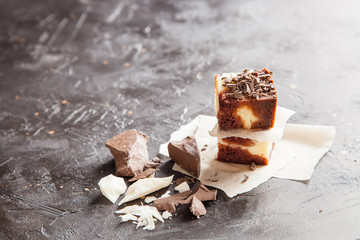 brownie with white and dark chocolate on a dark background, selective focus, copy space