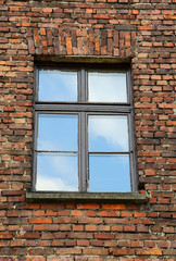 brick wall with a rectangular window and the reflection of the s