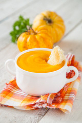 pumpkin cream soup on a table with ingredients, selective focus, copy space