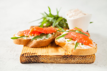 cheese, red fish and arugula sandwich on a board, selective focus, copy space