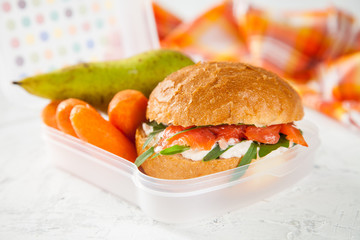 sandwich, pear and carrots in a lunchbox on a table, selective focus, copy space