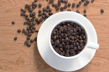 Coffee cup and coffee beans on wooden background. Top view.