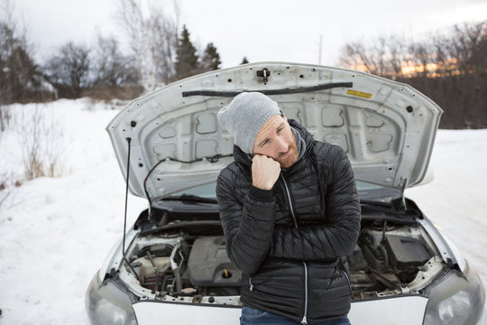 Man problem close to the broken car in winter