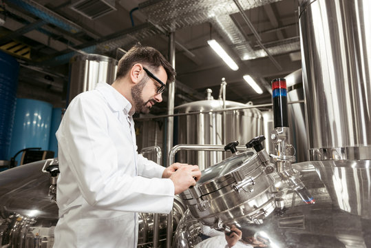 Concentrated man looking at brewing mechanism