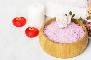 Obraz na płótnie Canvas Bath salt with aroma of a rose in a wooden bowl, petals and a fr