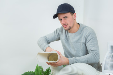 young technician installing air conditioning system indoors
