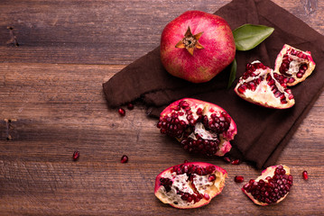 Pomegranate fruits with grains on wooden table. Top view.
