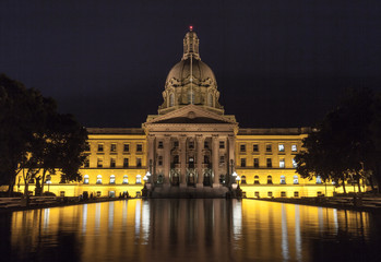 Alberta Legislature at night with lights reflecting into pool