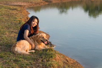 woman and golden dog on riverside