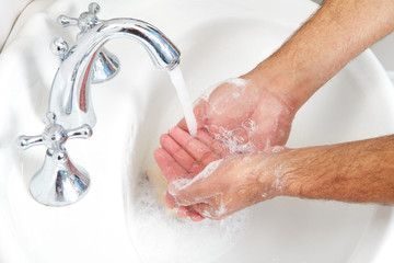 Male washing her hands in bathroom