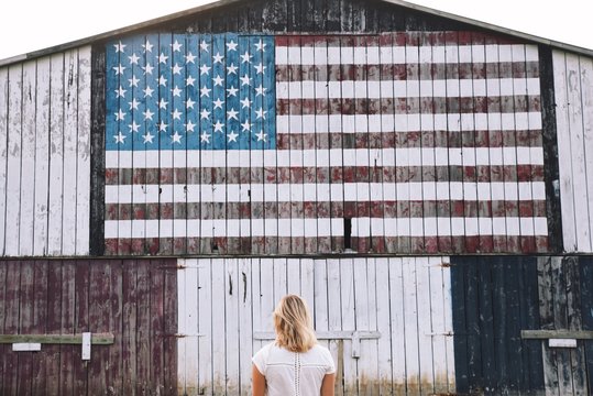 Woman in front of building with American flag 