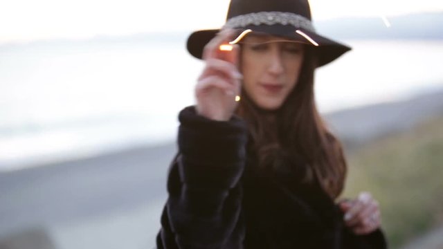 Girl with black jacket is dancing on the beach with the led lights 