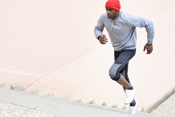 Black man running upstairs outdoors in urban background