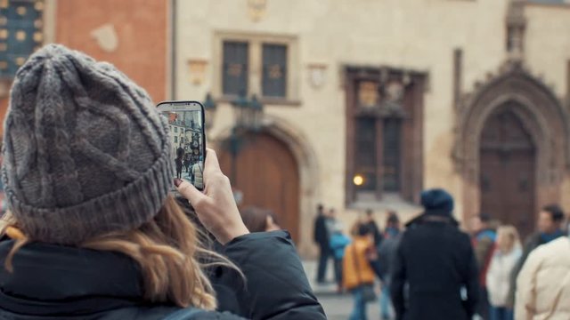 Prague, Czech Republic- December 24, 2016: Young girl films the old building - Old Town Square