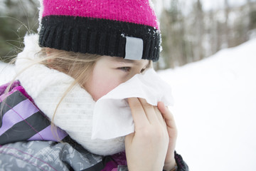 child with tissue outside in forest winter season