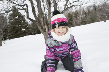 Fototapeta na wymiar Little girl in winter pink hat in snow forest.