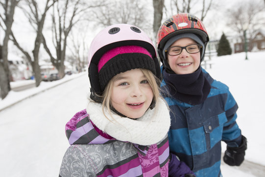 little girl and brother enjoying ice skating in winter season