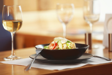 Plate with delicious salad on served table in cafe