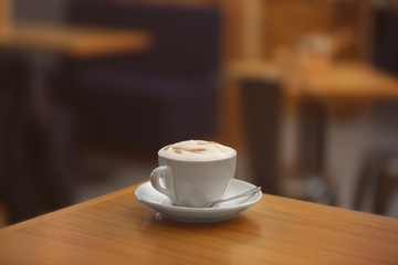 Cup of tasty cappuccino on table in cafe