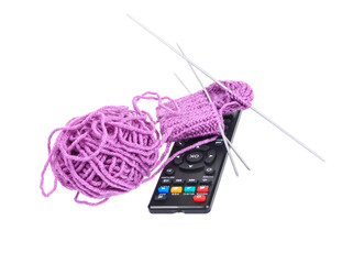 Ball of wool socks, spokes and remote tv on white background