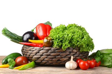 Fresh vegetables in wicker basket on table